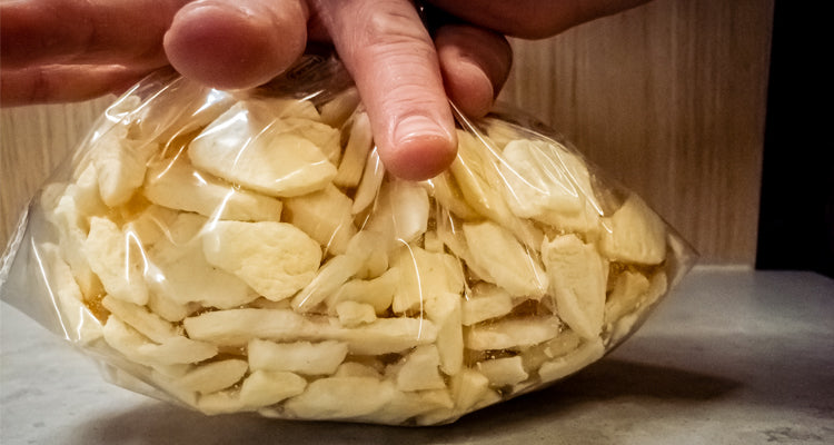 Squeezing zip lock bag full of cinnamon apples