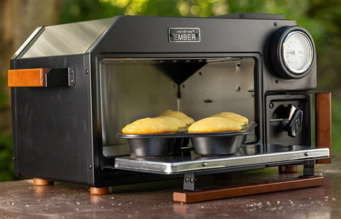A portable emergency oven with mini bread loaves baking inside.