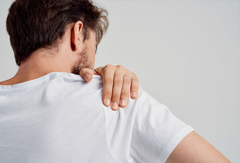 Man grabbing his shoulder that is aching.