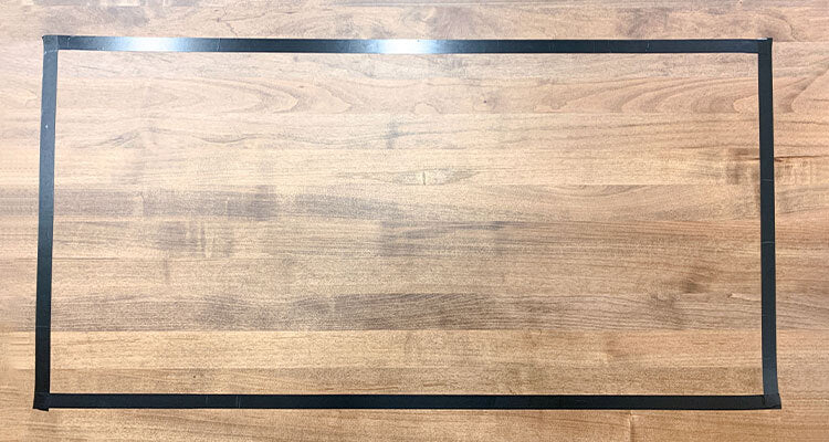 wood surface with a rectangle of electrical tape