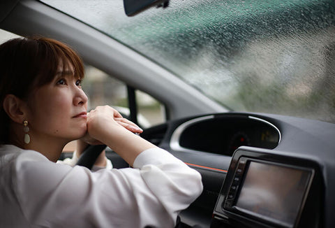 Woman inside a car in a heavy rain storm. 