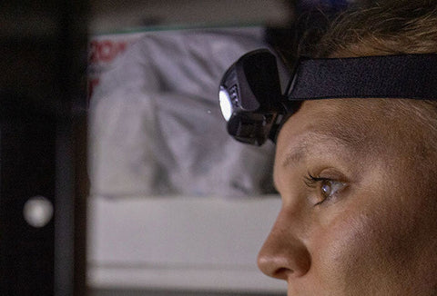 Woman wearing a black headlamp to see in the dark.