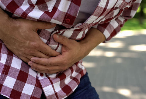 Person grabbing their stomach in pain.