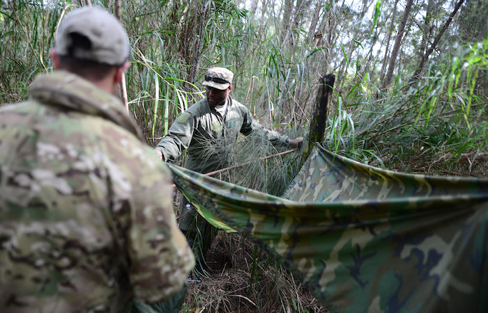 survivalists building outdoor shelter