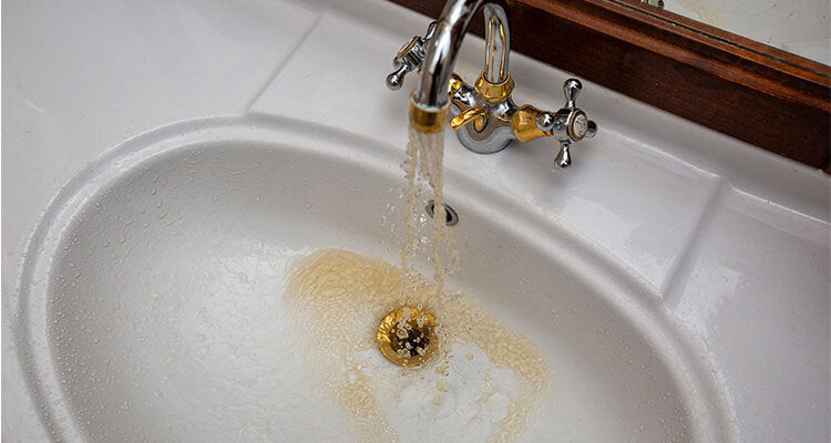 yellow water coming out of a sink faucet
