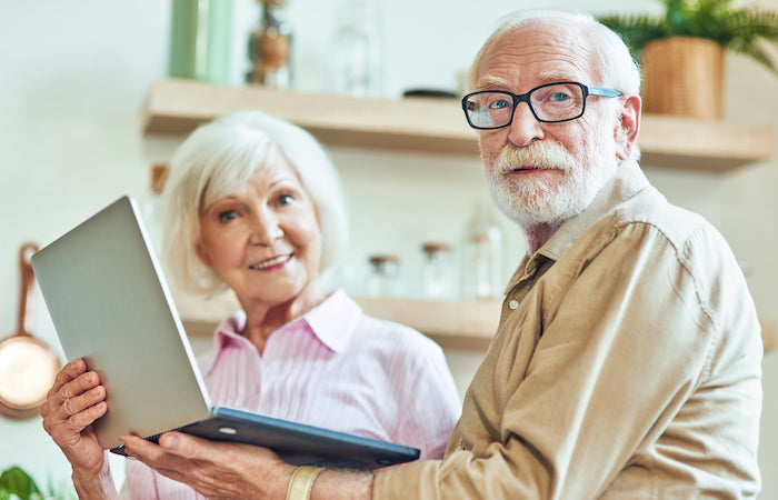 elderly man and woman making a plan next to a computer