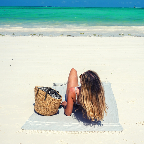 jeune femme sur plage avec foutas chevrons