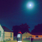 Person standing under the moon in a hoodie