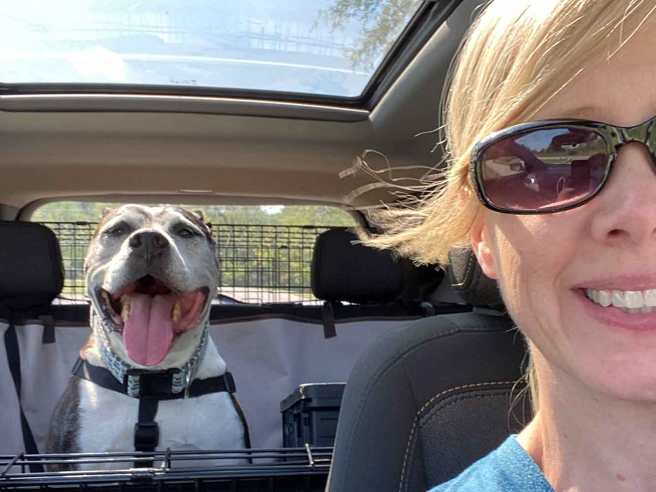 Snuggle Puppy Employee taking a selfie in the car with an adopted shelter dog