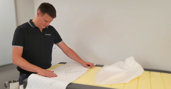 Bryce tests the softness of a potential material for the baby mattresses