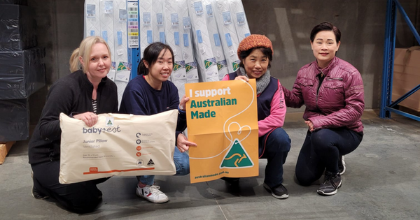 Mai with her team holding some of the Australian Made Junior pillows they have created