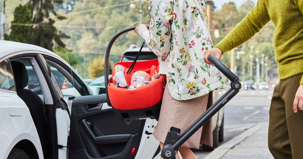 Parents transferring a baby capsule into their car