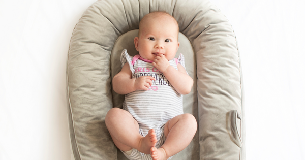 A baby lying in a beige baby loungers