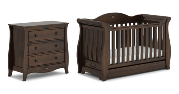 A really dark, ornate wood matching cot and chest side by side with curves that resemble a sleigh