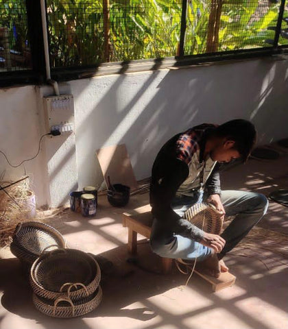 Man weaving cane trays