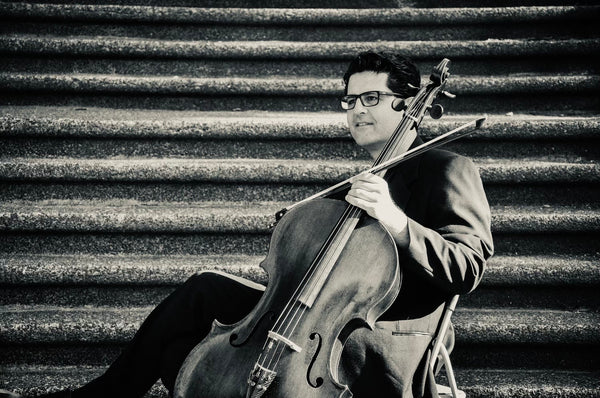 Peled shown sitting with his cello, in black and white