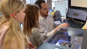 Students operates FLUX laser cutter