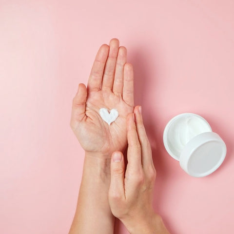 Heart of facial cream sits in person's hand