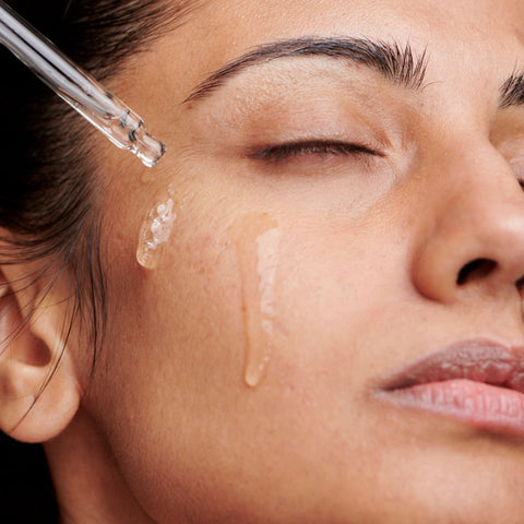 woman applying serum to face