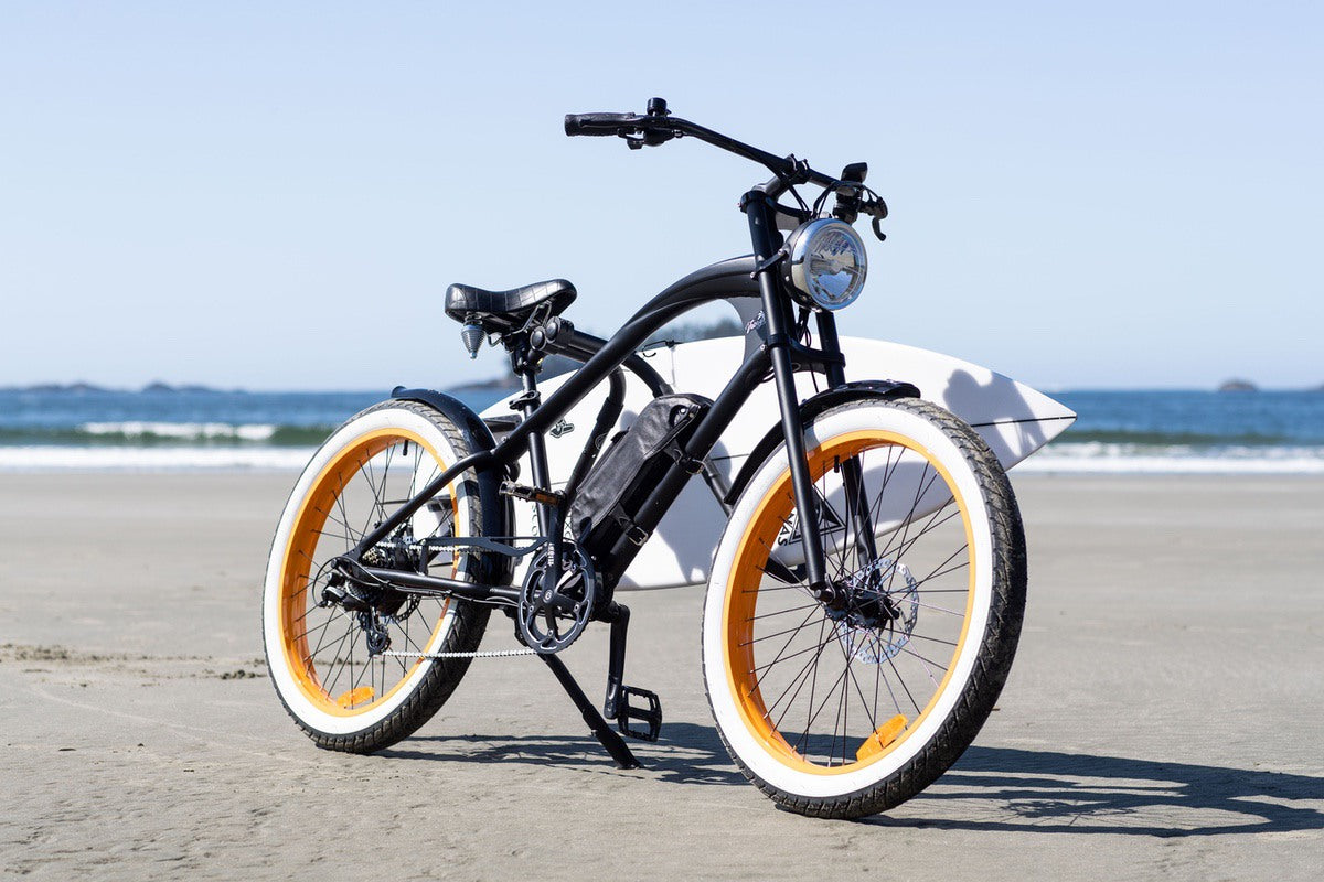 Michael Blast Vacay Hi Step eBike on beach in front of surfboard