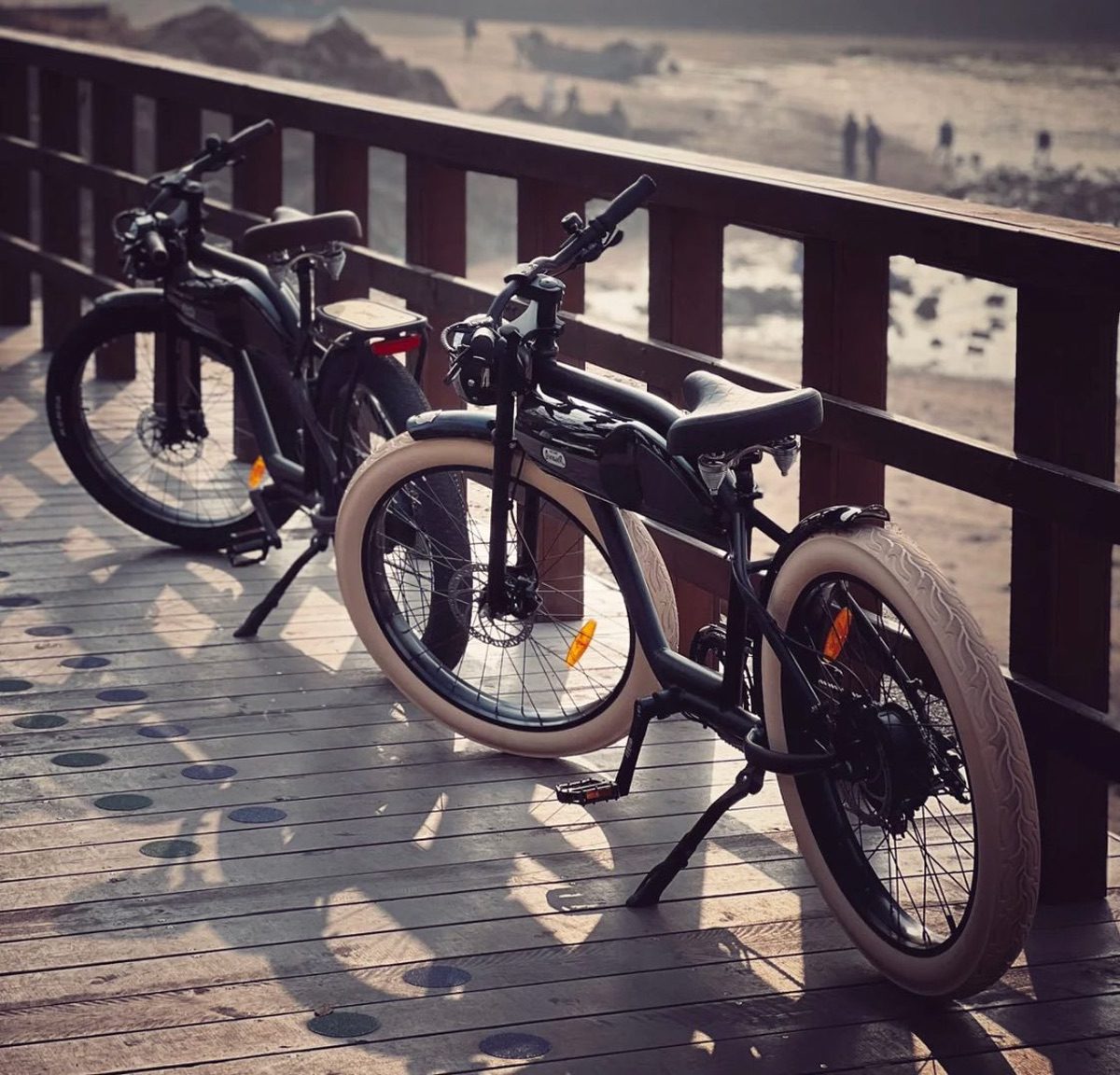 Two Michael Blast eBikes parked on boardwalk during the day