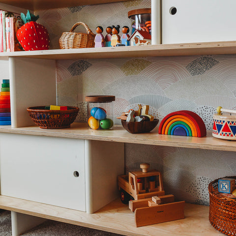 Blocks and other wooden toys in the current toy rotation on a playroom shelf.