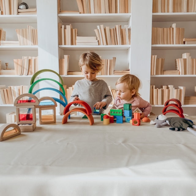 Two children playing with toys on table with books in the background | Oompa Toys