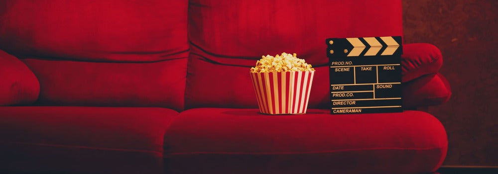 Red couch with popcorn and director's clapperboard