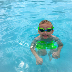 boy swimming in pool wearing Frogglez goggles