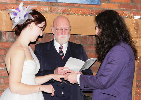 The Feathered Head Bride of the Month wearing white purple wedding feather fascinator headpiece