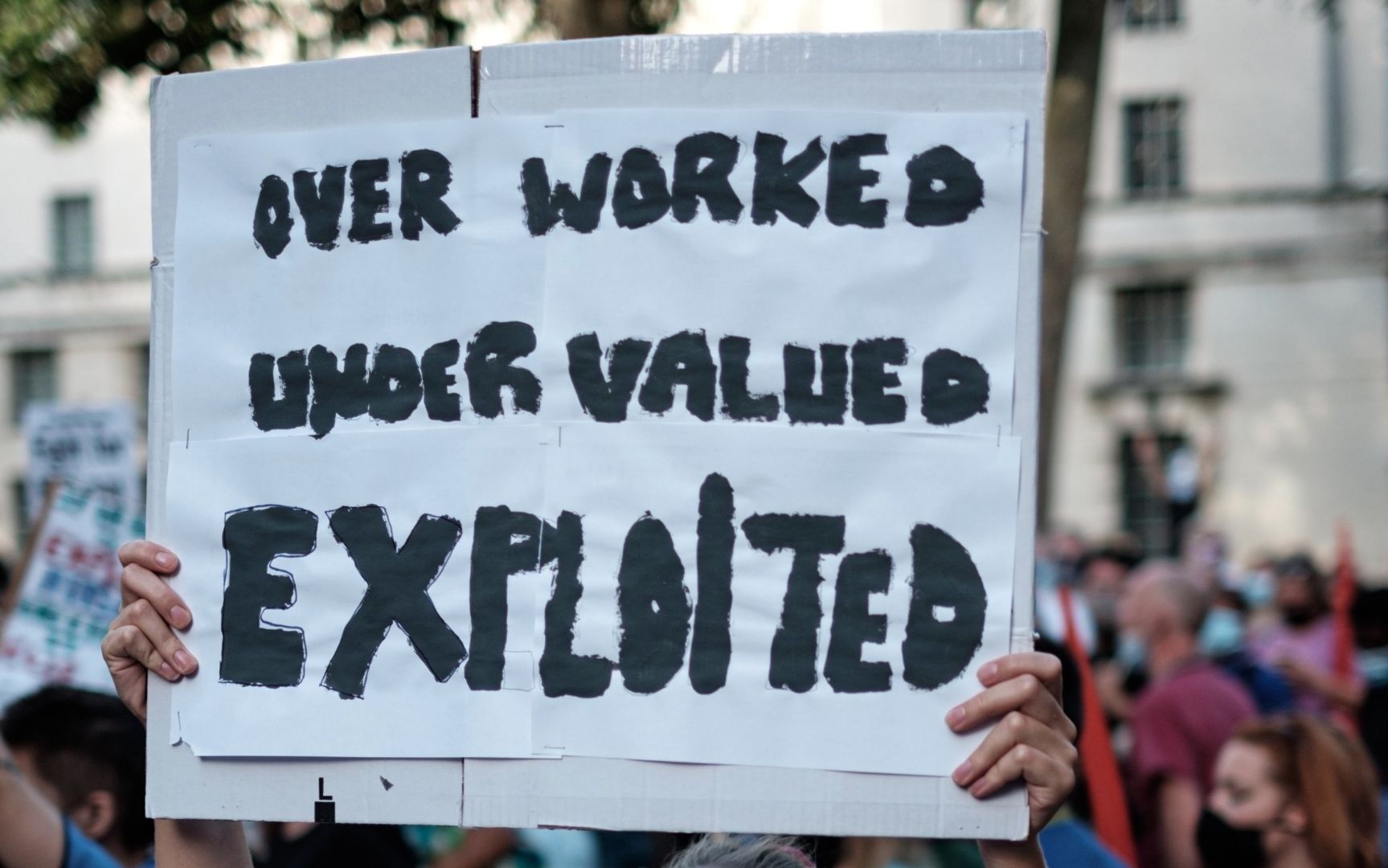 Bluewashing protest sign that says over worked, under valued and exploited