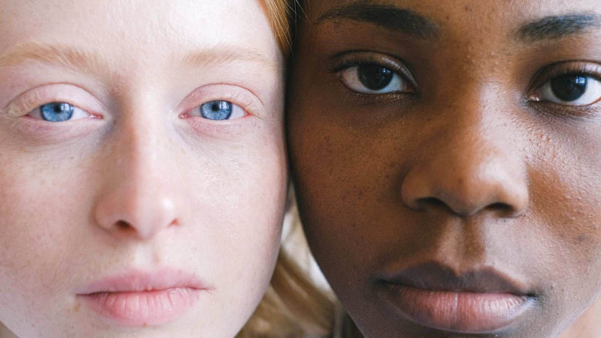 A pale, blue eyed woman's face next to a black, brown eyed woman's face