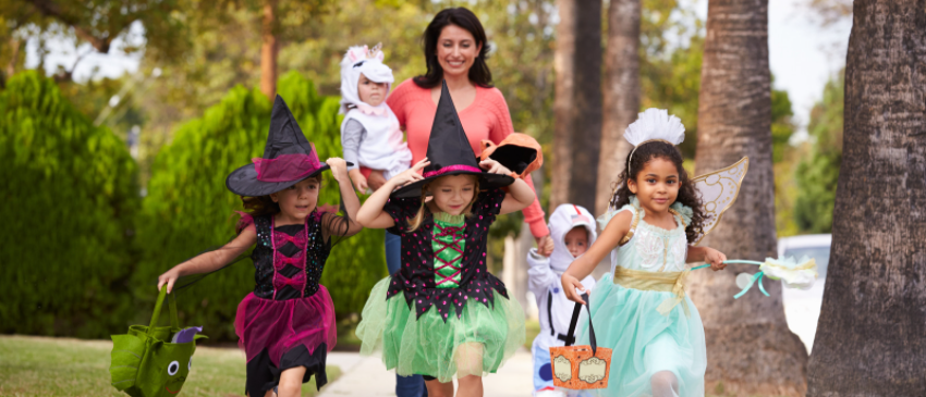 Mother with multi racial children trick or treating