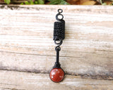 Banded Red Jasper Loc Bead on wood background.