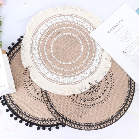 Round knitted placemat set with patterns made of high quality cotton and linen with patterns in boho and macramé beach style in colors beige white and black on a dining table for decoration and as a place mat