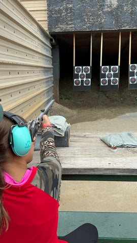 a young girl practicing her gun safety at the shooting range