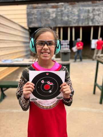 a young girl practicing her gun safety at the shooting range