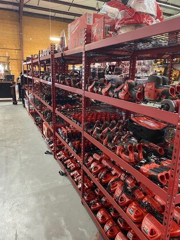 A row of shelves full of used power tools for sale.