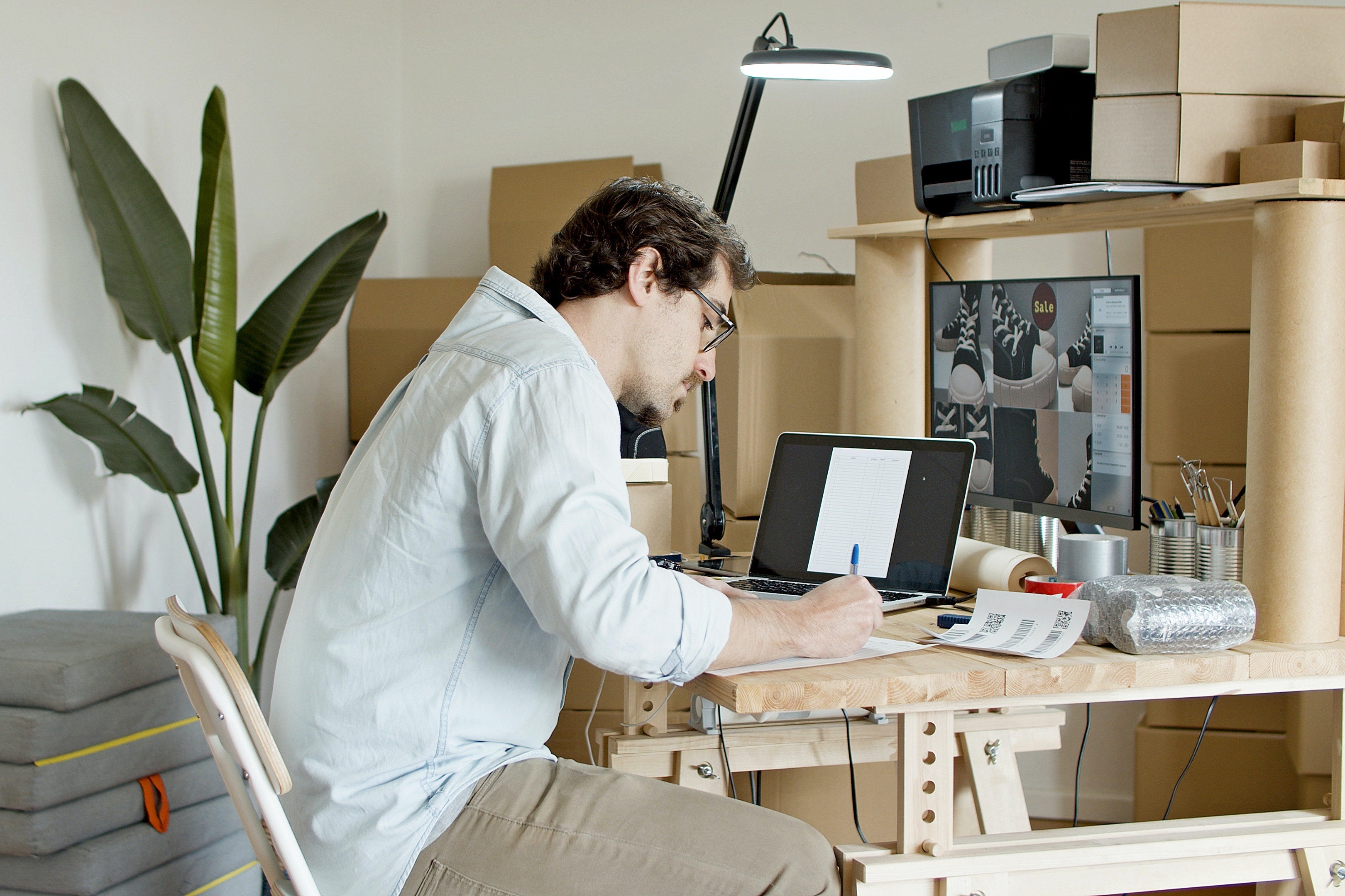 man sitting with a laptop and packages