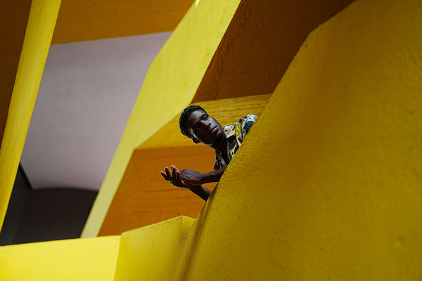 Wide-angle shot of a man in a yellow stairwell.