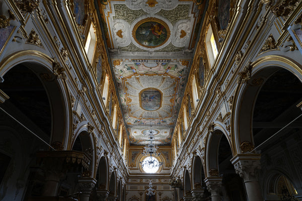 An ornately decorated interior with gold trim and numerous frescoes.