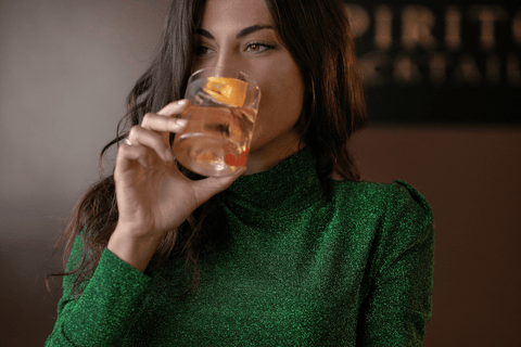 Ragazza che sorseggia un Old Fashioned cocktail