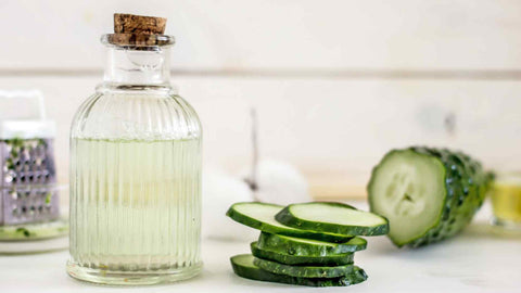 sliced cucumbers next to clear glass bottle