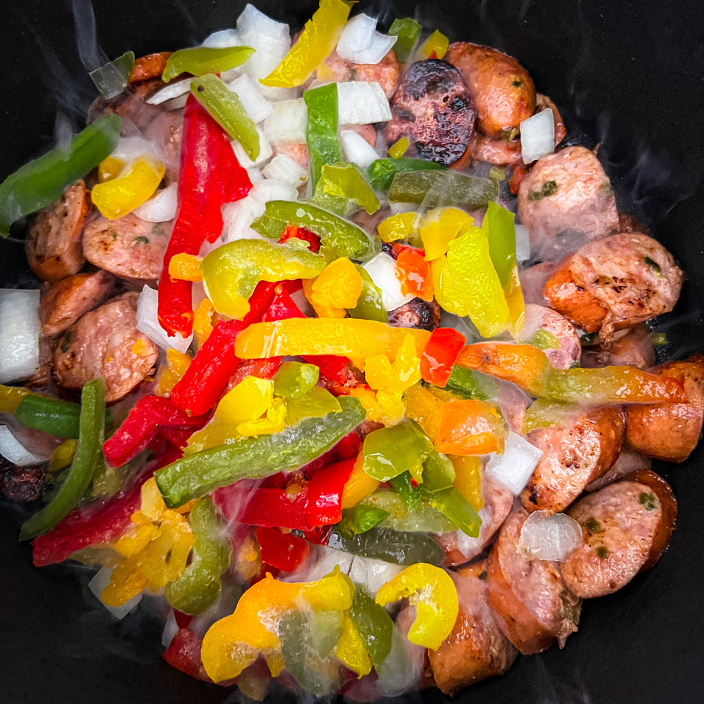 browned sausage sauteeing with bell pepper, onion, and celery