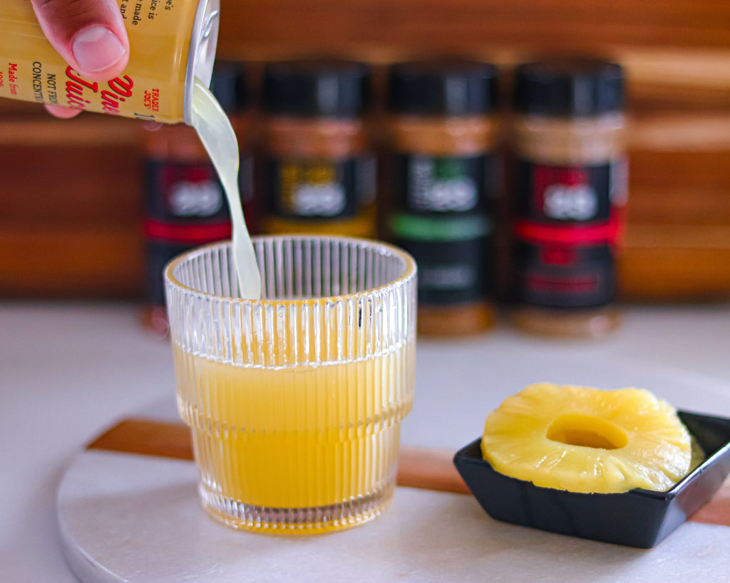 pineapple juice poured into glass with station 1923 seasonings in the background - pineapple juice to tenderize meats naturally