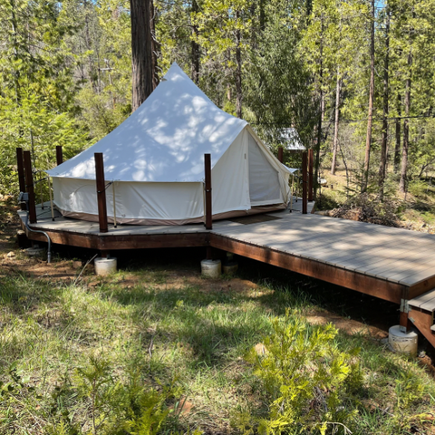 canvas bell tent on wooden deck platform