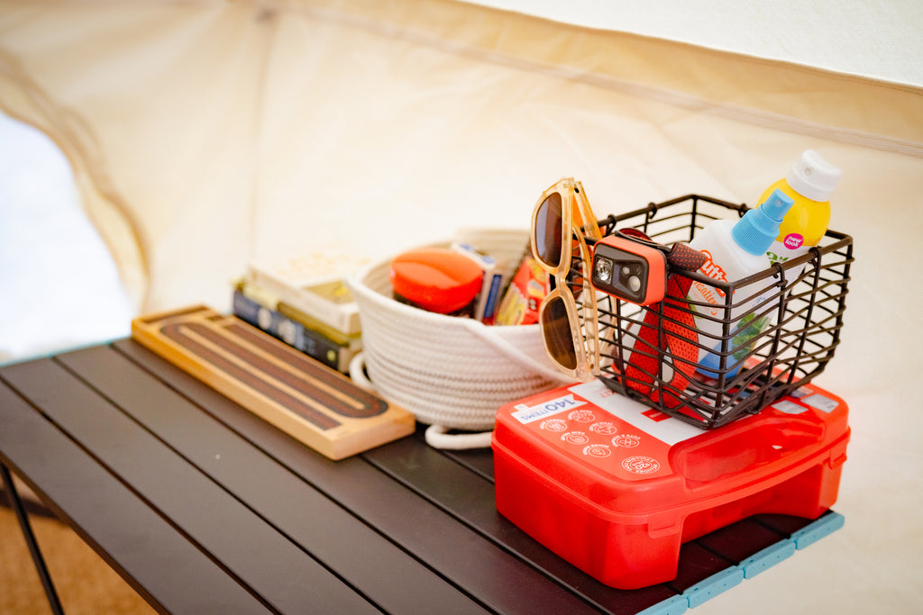 Una pequeña mesa contiene algunos artículos familiares esenciales como primeros auxilios, protector solar y gafas de sol.