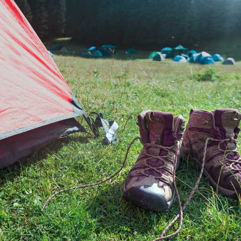 bottes sales à l'extérieur d'une tente de camp