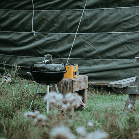 charcoal grill cooking area outside of canvas tent