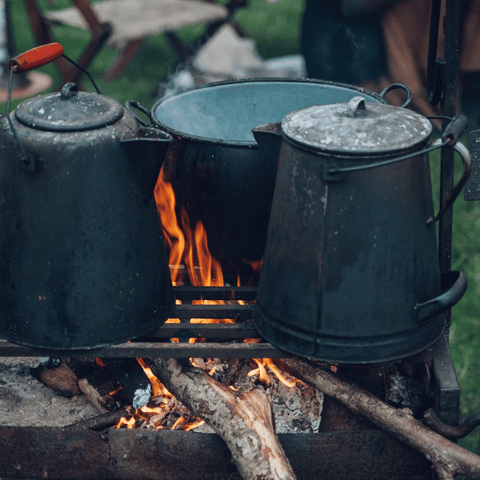 Hervidor de café esmaltado sobre fuego de campamento